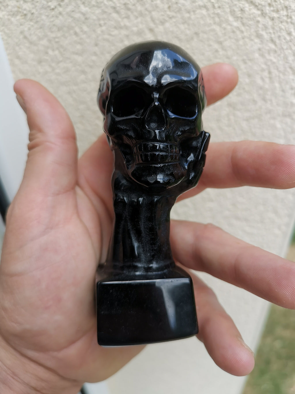 Obsidiaan sculptuur, hand die een schedel vasthoudt / Natuurlijke verzamelaarsteen