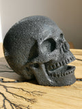 Zang-/lachende schedel van lavasteen · Natuurstenen sculptuur