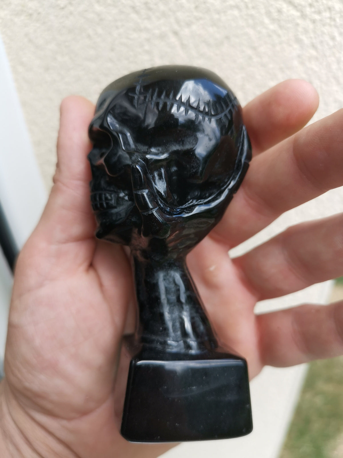 Obsidiaan sculptuur, hand die een schedel vasthoudt / Natuurlijke verzamelaarsteen